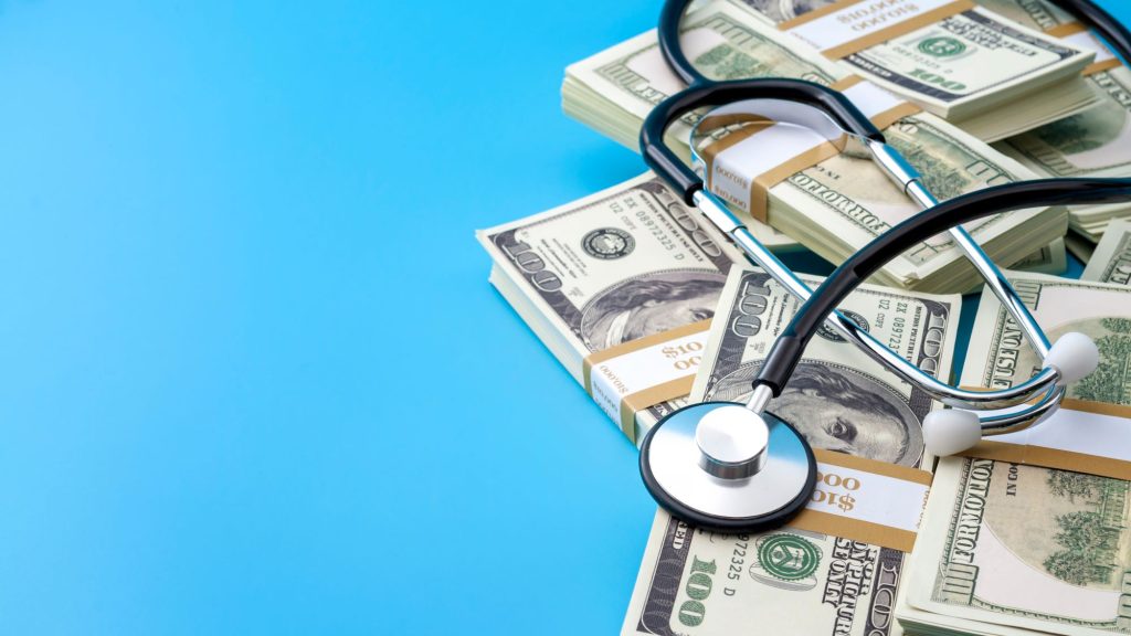 stethescope and dollar bills on a blue background