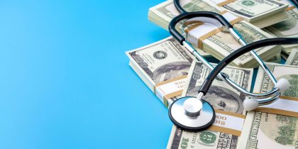 stethescope and dollar bills on a blue background