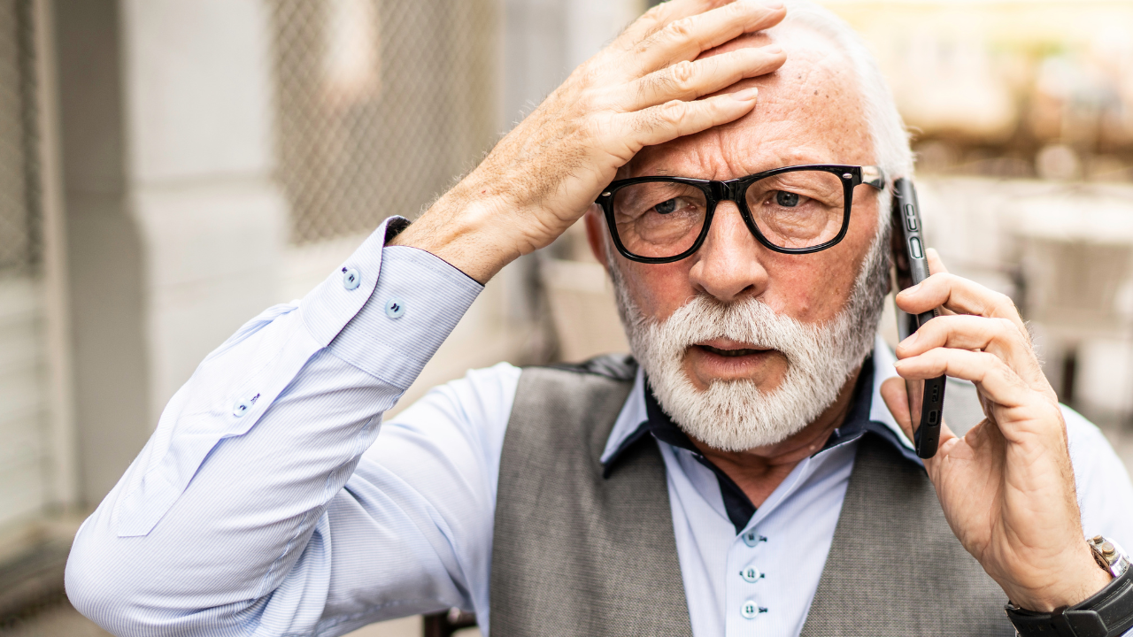 stressed senior man withglasses on the phone