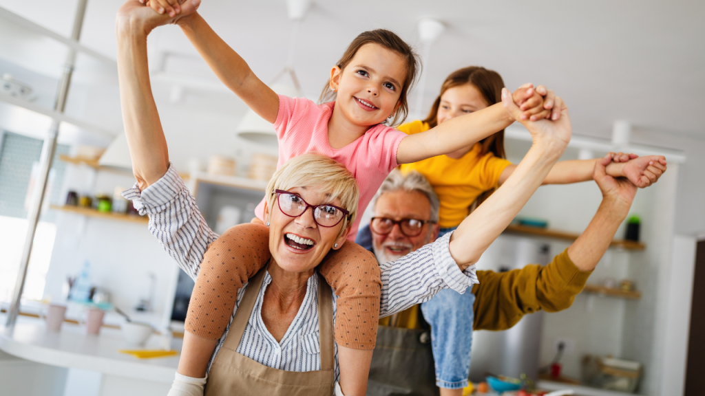 young grandparents with grandchildren on shoulders laughing