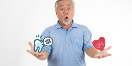 Asain senior man holding tooth and heart emojis with a surprised face