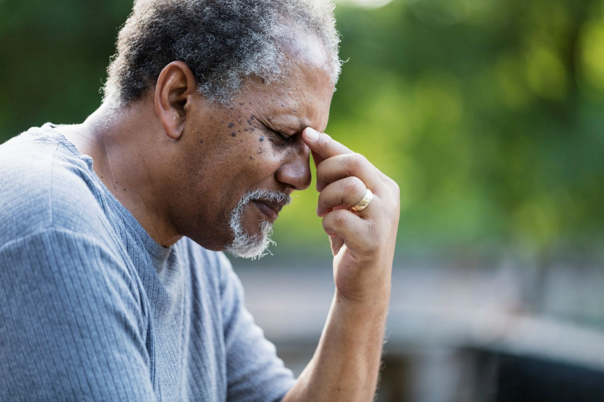 black older man gentleman pinching his nose bridge dealing wit eye strain