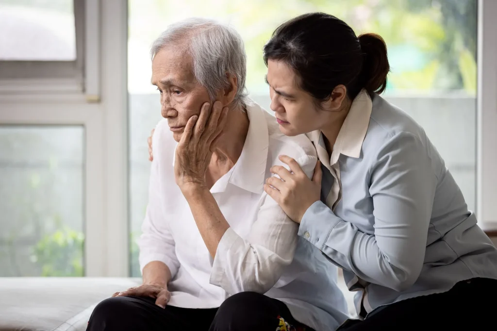 Loving daughter embracing comforting and consoling the old elderly, depressed stressed senior woman contemplating,afraid and worried about senile disease,thinking about health problems,life troubles maybe with alzheimer's disease