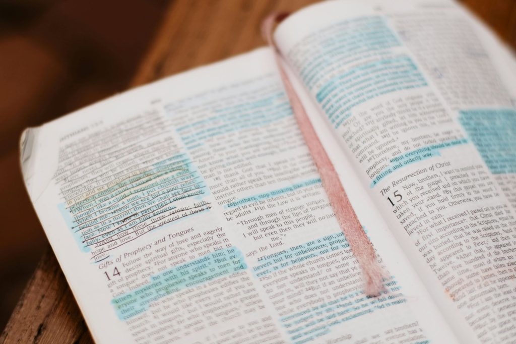 An open bible on a table with highlights on the page for specific verses.