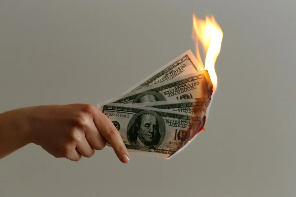 wasting money concept, burning through money, spending too much