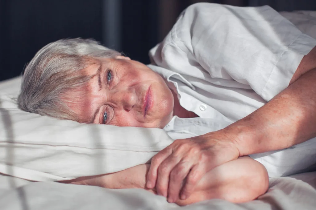 Sleepless middle-aged woman lying in bed suffers from insomnia sleep disorder cant sleep till morning, depressed elderly female looking upset thinking about life, health troubles concept