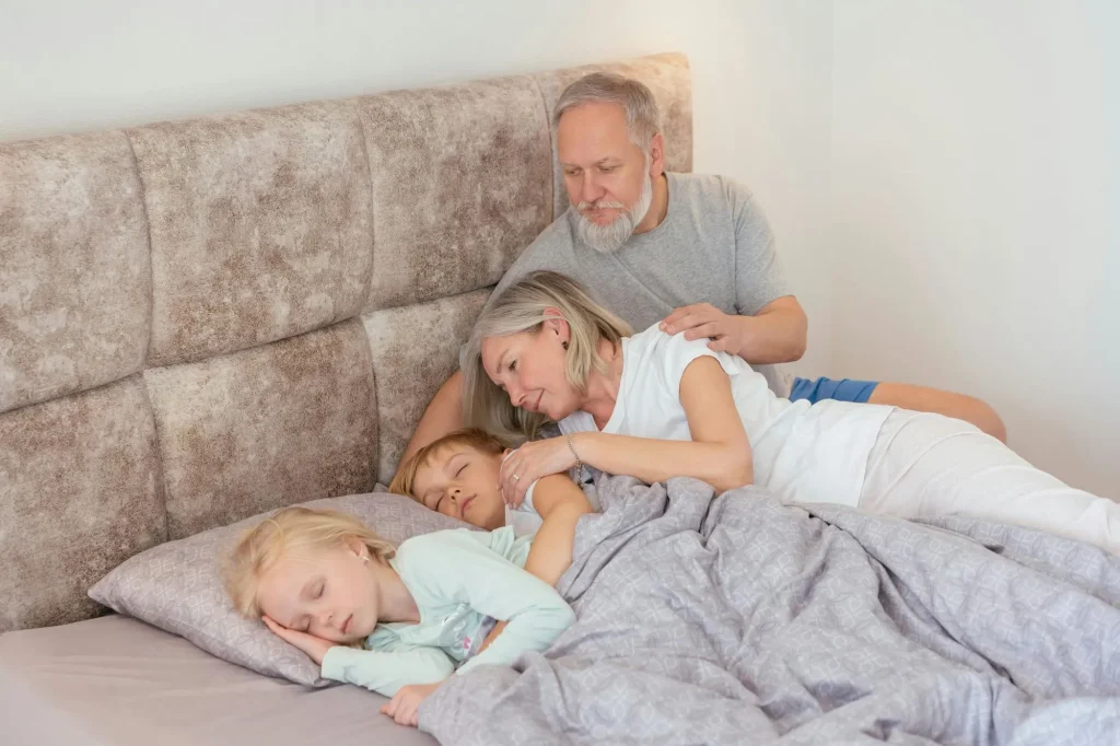 Grandkids sleeping and grandparents watching over them lovingly