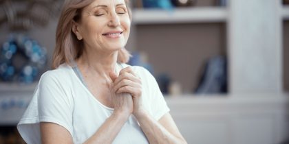 Happy Woman Is Pressing Her Arms To The Chest. Satisfied Woman With Closed Eyes Smiles And Presses Hands To The Chest. Portrait. Woman In Prayer Pose.