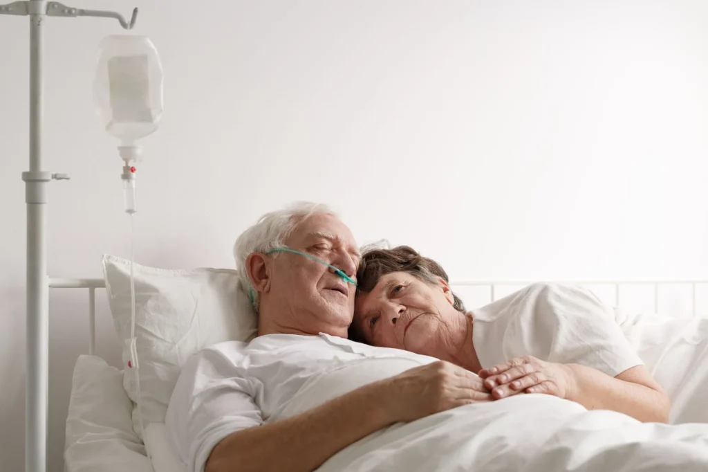 Shot of a sad wife lying next to sick husband at the hospital