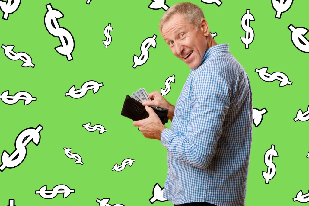 happy retired man holding wallet open with money, on green background with dollar signs all around him