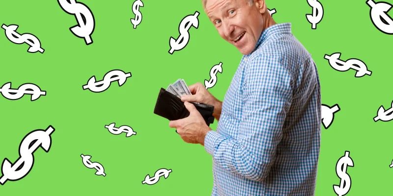 happy retired man holding wallet open with money, on green background with dollar signs all around him