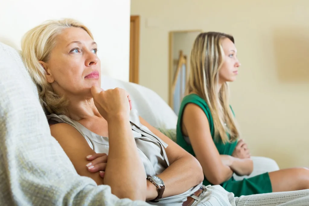 Mature mother and sad adult daughter having quarrel, argument
