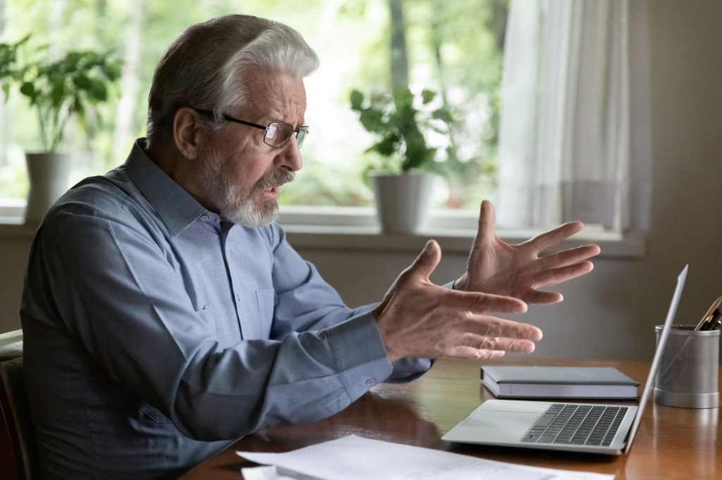 shock extending hands toward laptop