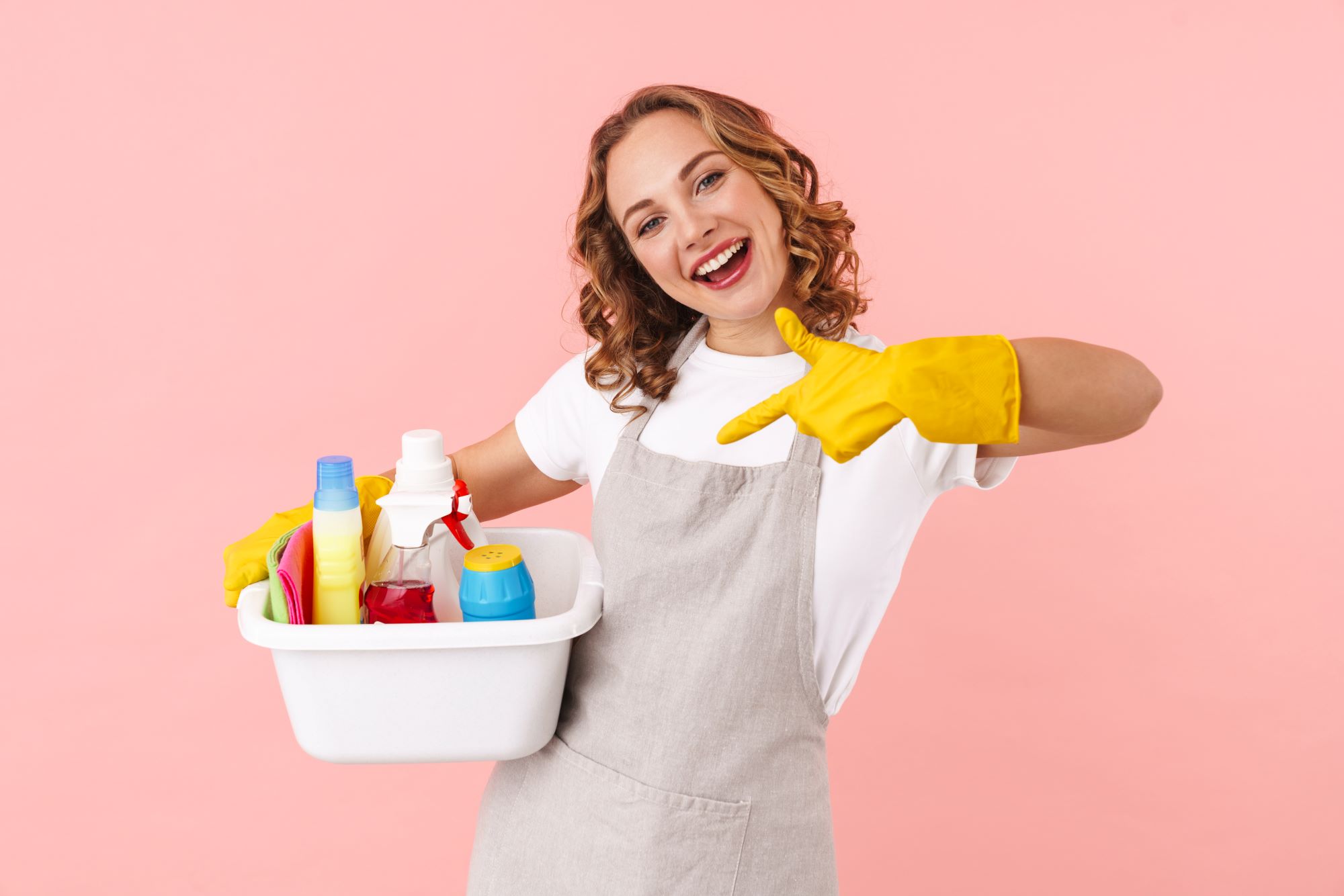 cleaner pointing to supplies pink background