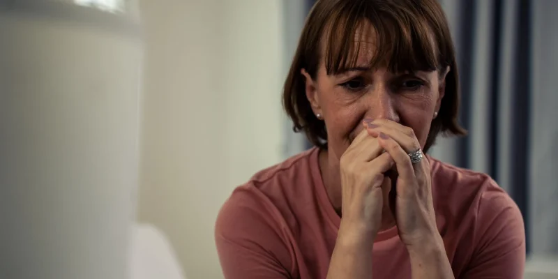 Caucasian senior older depressed woman sit alone in bedroom at home