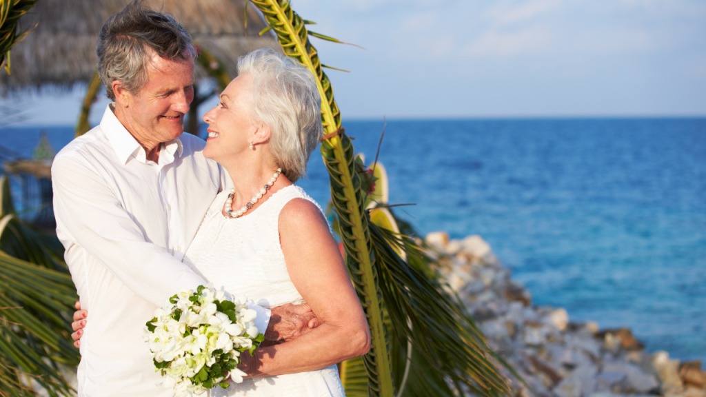 senior couple getting married on a beach by water