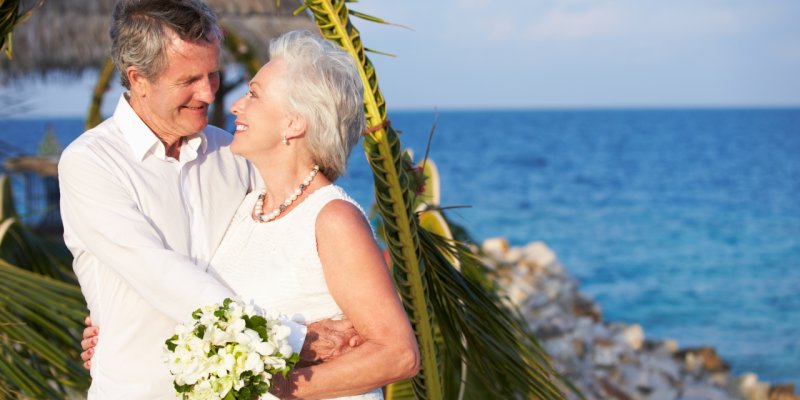 senior couple getting married on a beach by water
