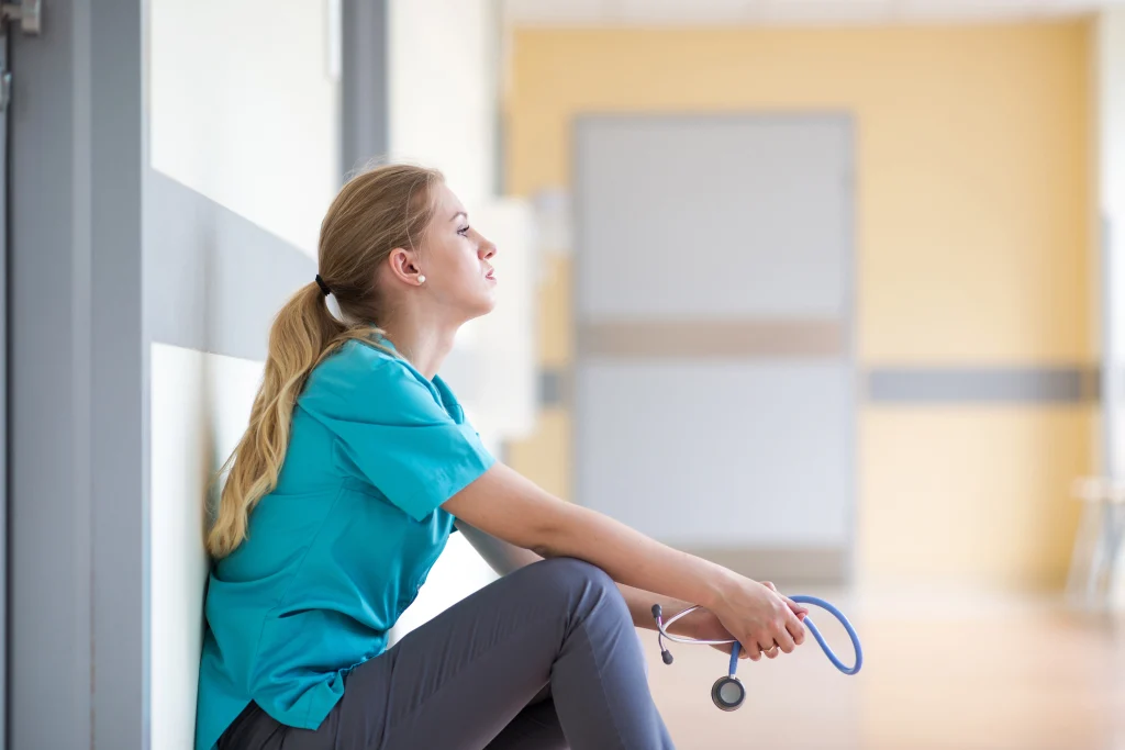 Tired female nurse in hospital corridor