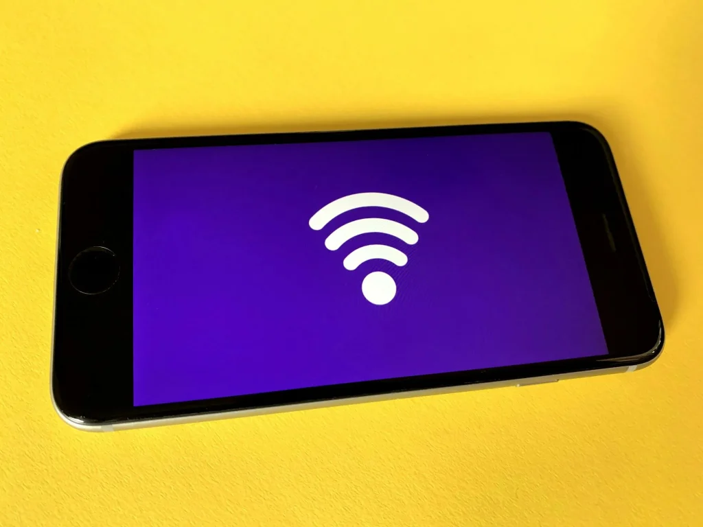 wifi internet symbol on a phone sitting on a bright yellow background
