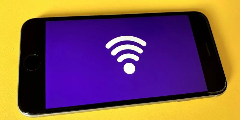 wifi internet symbol on a phone sitting on a bright yellow background