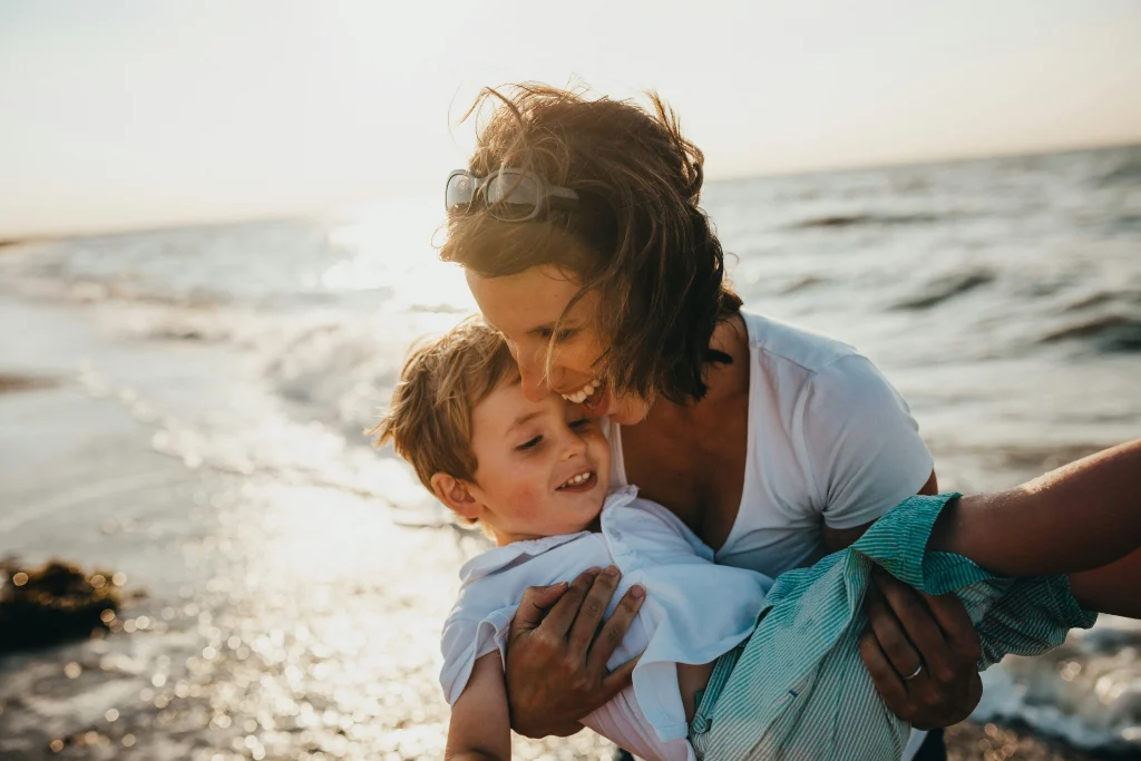 young grandma and grandchild playing on the beach