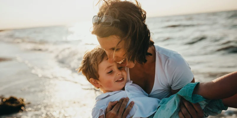 young grandma and grandchild playing on the beach