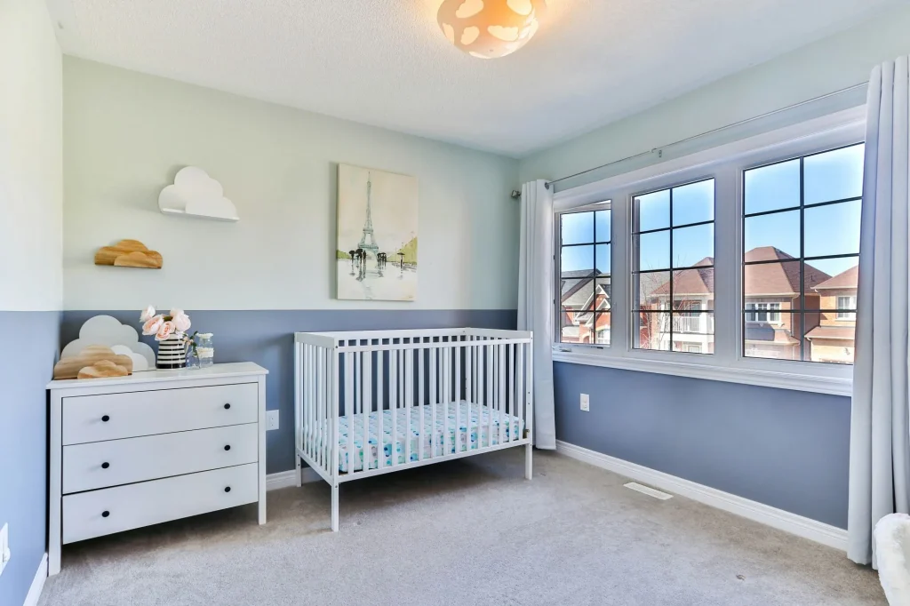 baby crib, dresser, in a blue but neutral nursery