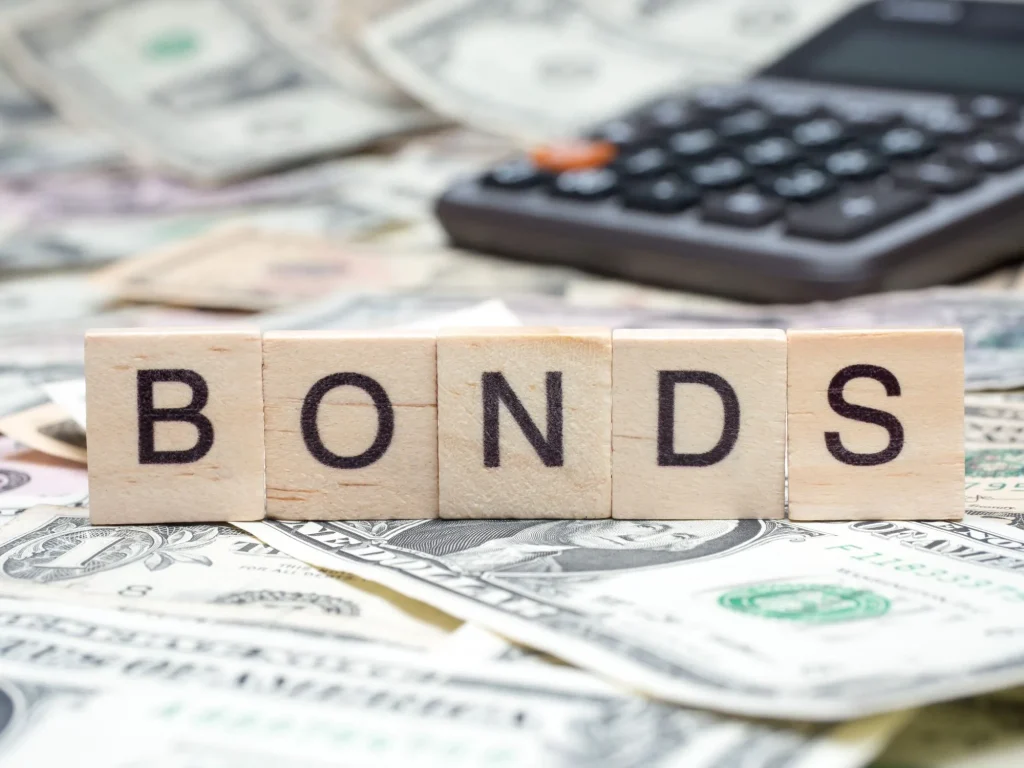 Word "BONDS" in wooden block on US Dollar bills