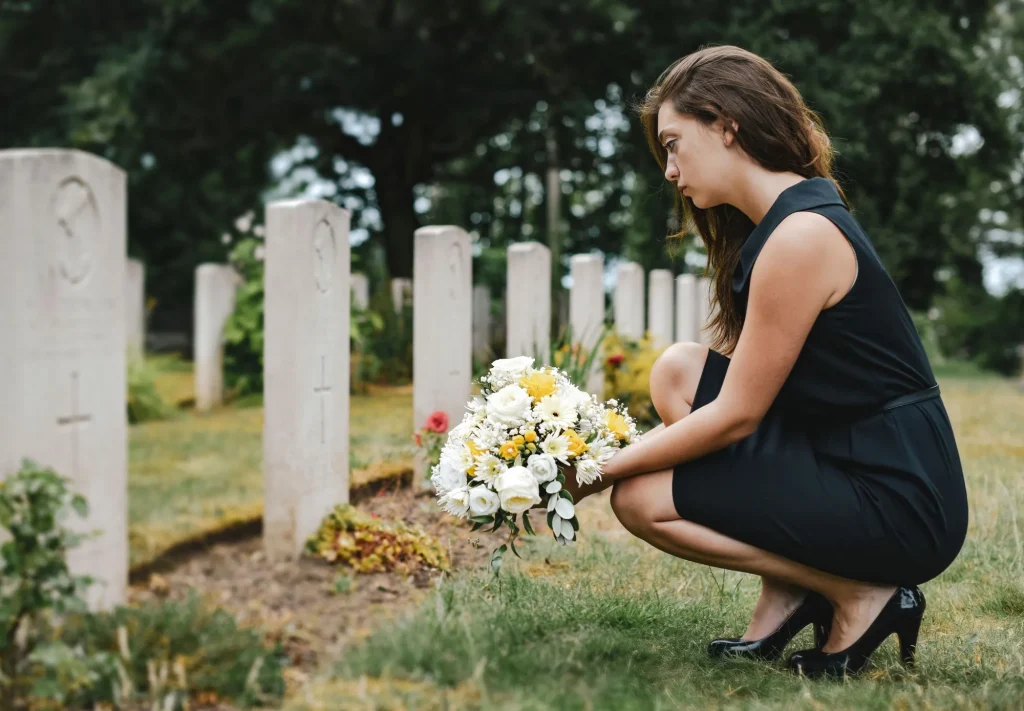Adult woman laying flowers on grave