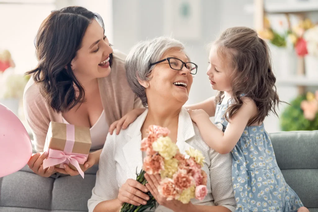 grandmother receiving a mother's day gift from her daughter and granddaughter