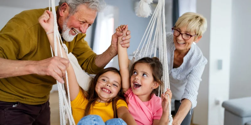 Grandchildren having fun, playing with grandparents at home