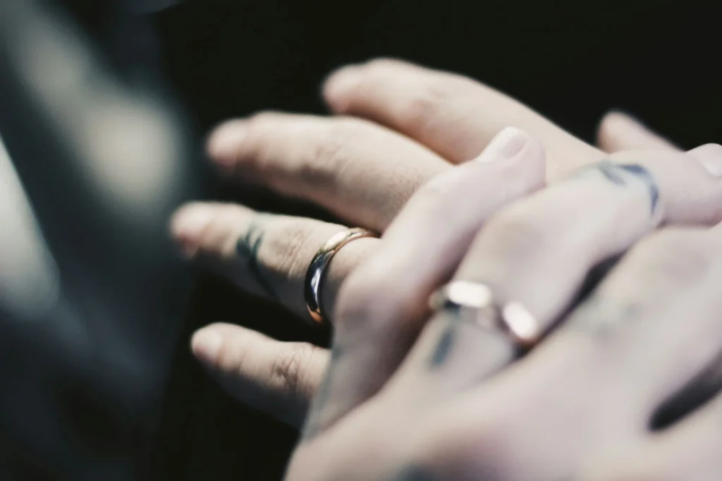 couple's hands, close up of wedding rings, hands on top of one another