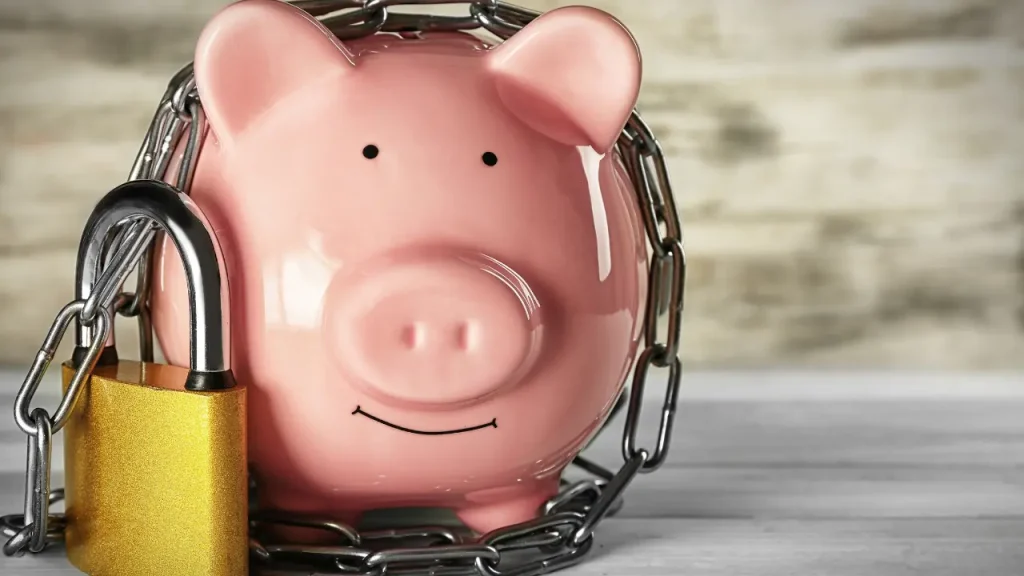 locked up piggy bank on a dollar bill background, non-liquid asset concept