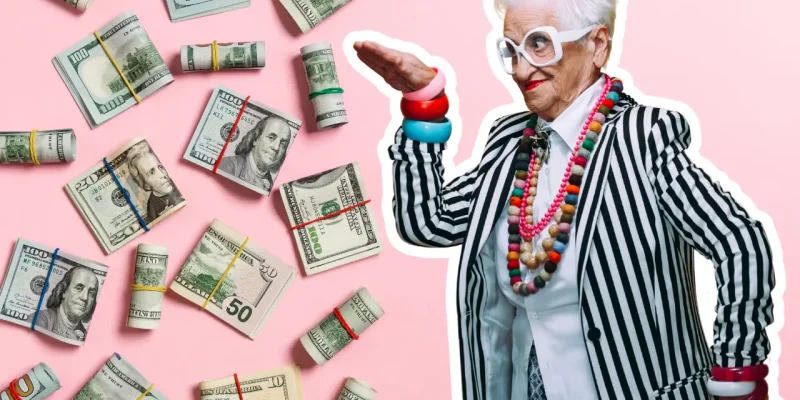 Silly senior woman dressed with lots of accessories on a pink background surround by money