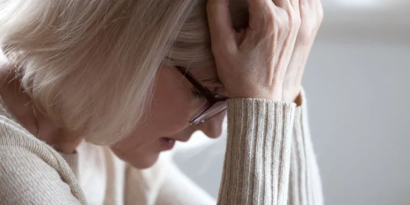 Stressed sad tired middle aged senior woman holding head in hands feeling headache migraine concept, upset old elderly mature lady in panic suffering from pain, alzheimer disease, anxiety depression, stressed and praying