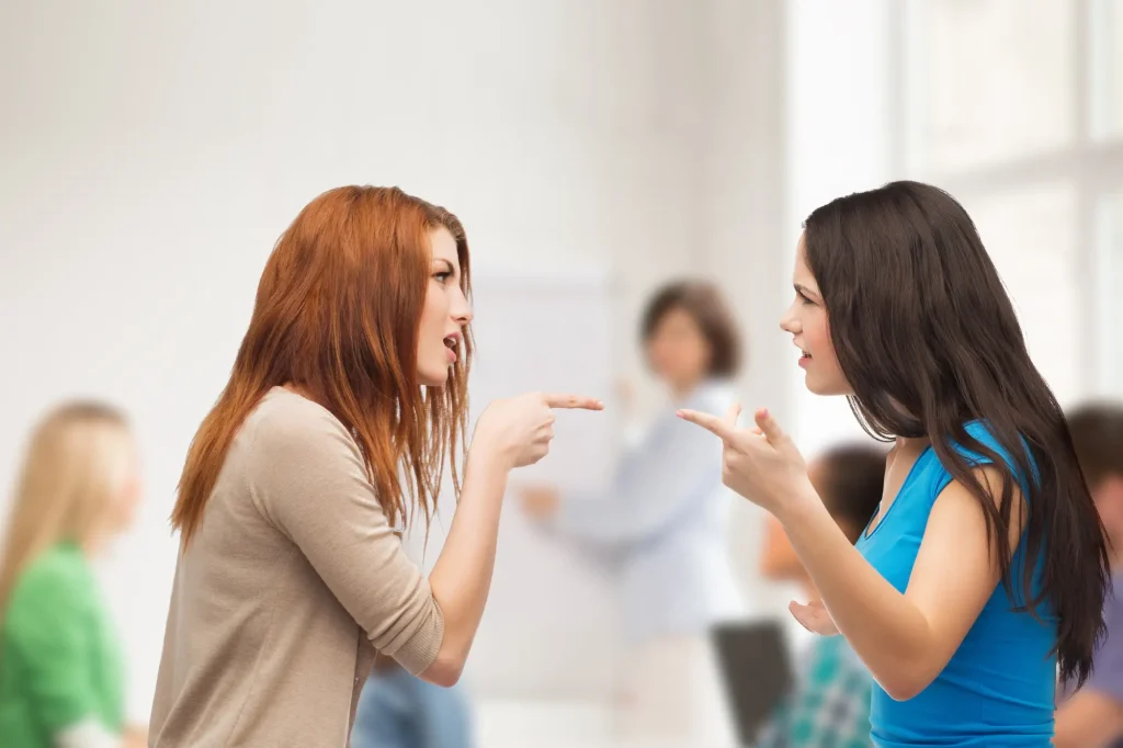 angry woman pointing at angry brunette