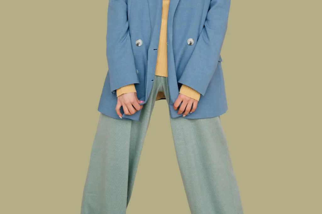 lady in baggy blue blazer, yellow turtleneck, and baggy gray pants
