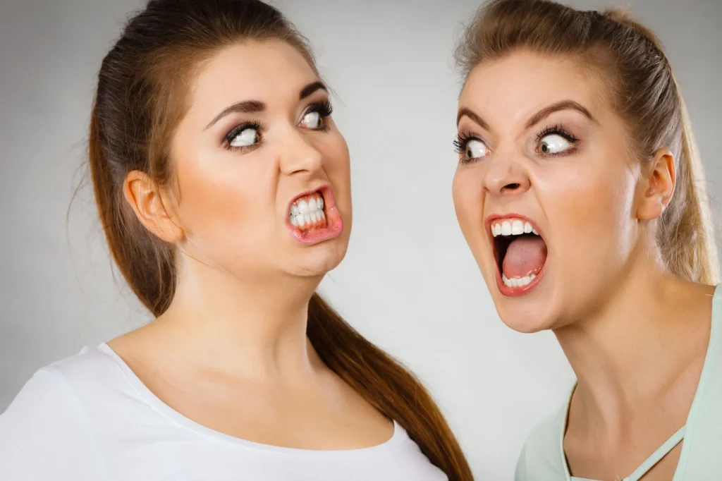 Two agressive women having argue fight being mad at each other.