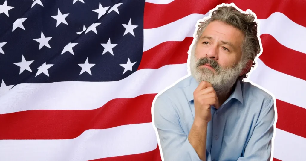 senior man with gray beard thinking in front of an American flag
