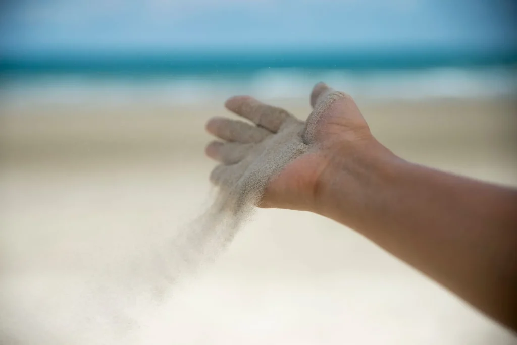 Let it go, Freedom hand , and Release concept. Hand let go of woman release sand on beautiful sea beach and blue water background