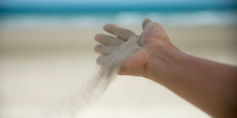 Let it go, Freedom hand , and Release concept. Hand let go of woman release sand on beautiful sea beach and blue water background