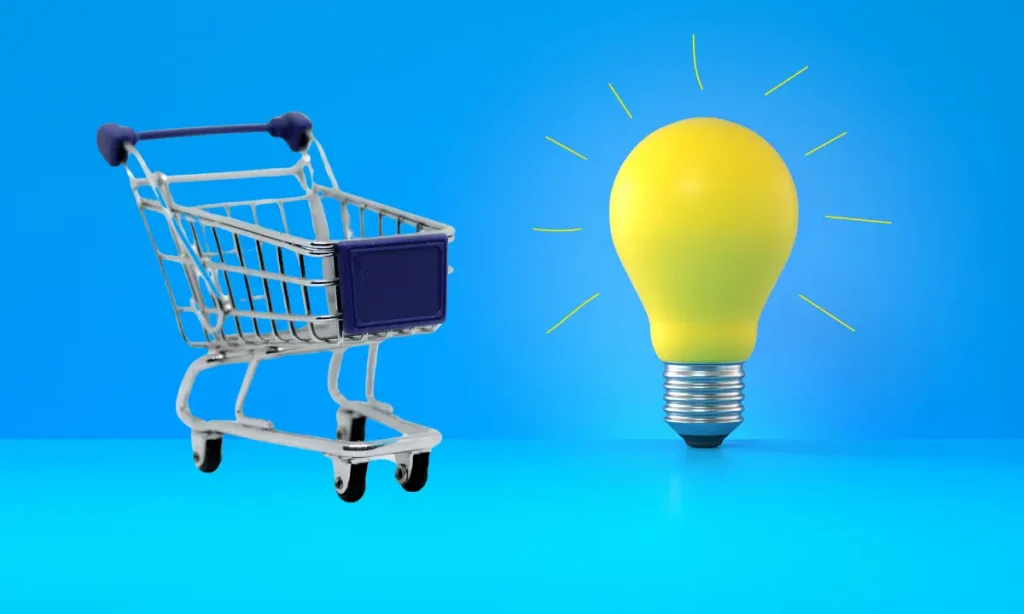 blue shopping cart on a blue background next to a yellow lightbulb