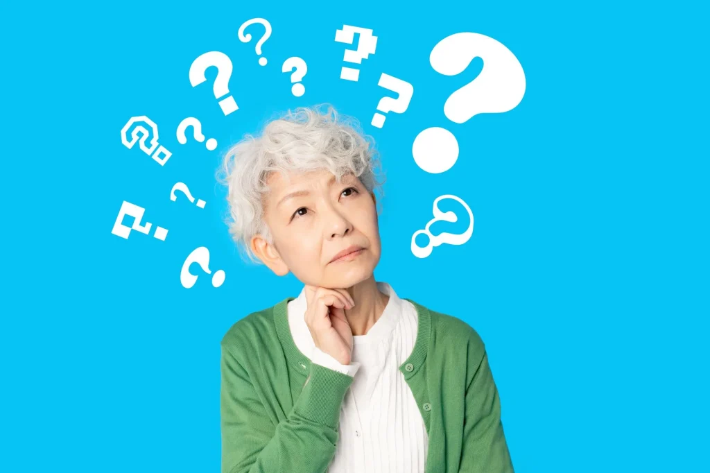 Asain senior woman with lots of question marks all around, thinking, worrying