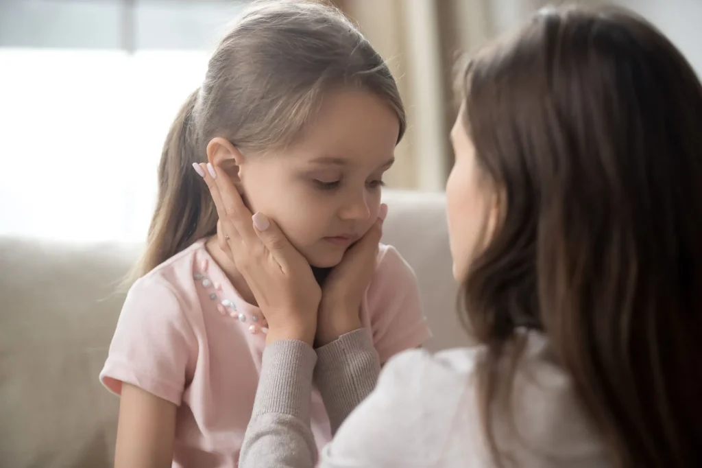 touching upset little daughter face, expressing support, young mum comforting offended adorable preschool girl, showing love and care, child psychologist concept, close up