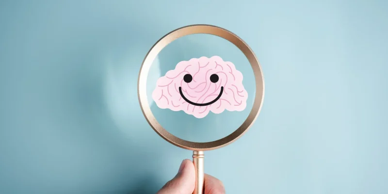 Magnifier focus to human brain and smile mental health sign positive thinking, idea creative intelligence thinking or Awareness with energy boost, energy or fresh wellness emotion concept.