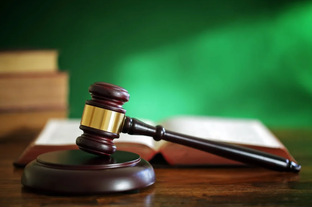 Legal system concept gavel in front of a green wall