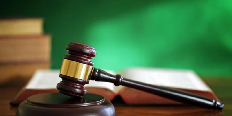 Legal system concept gavel in front of a green wall