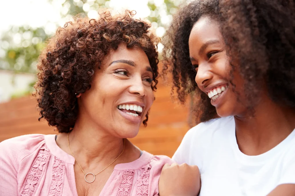 mother and adult daughter smiling