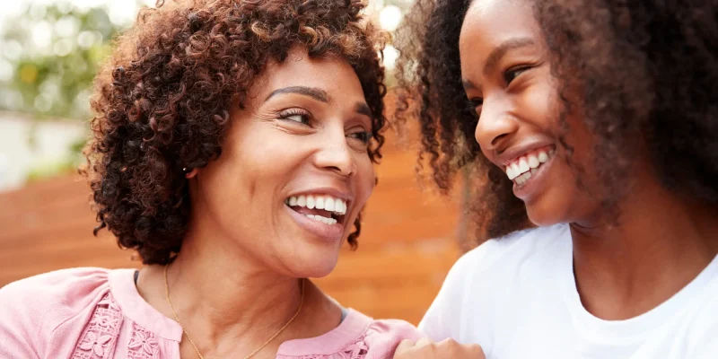 mother and adult daughter smiling