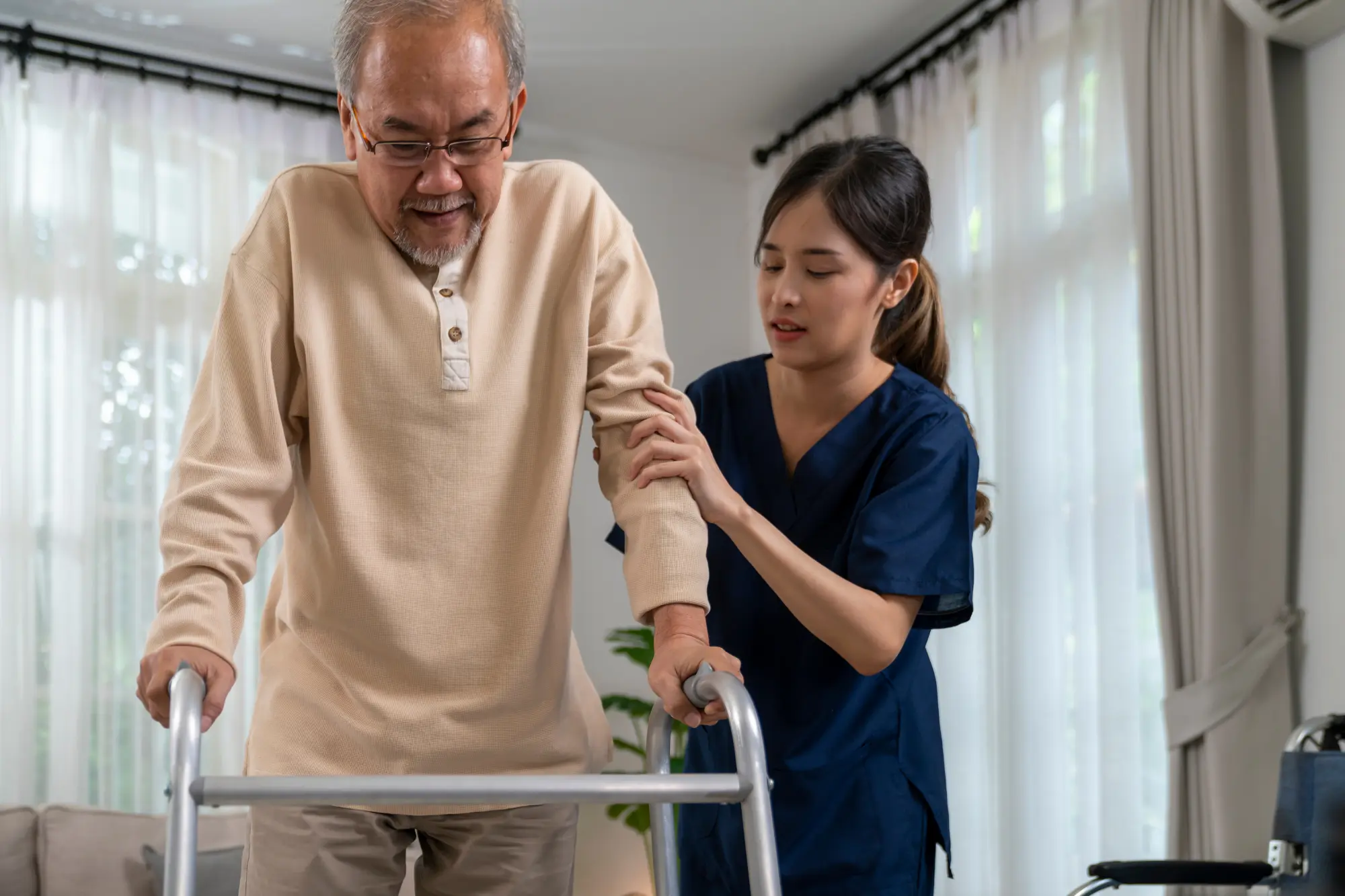 caregiver or nurse helping a senior man with a walker
